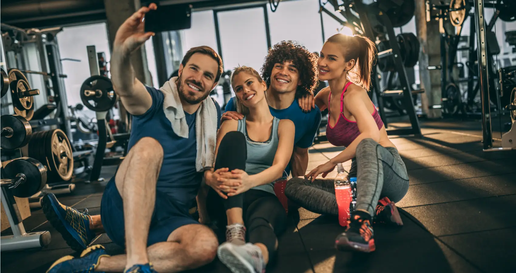 A group of four friends taking a smiling selfie together after a workout at Catalyst Training Co gym in Randwick.