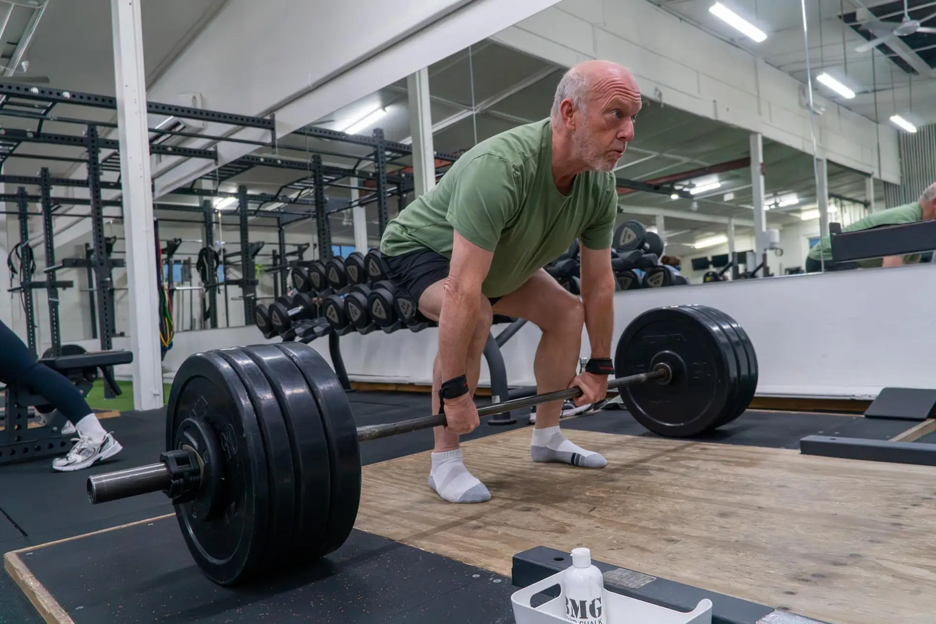 Older man setting up a heavy deadlift with wrist straps at Catalyst Training Co. gym, Sydney eastern suburbs.